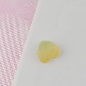 Macro detail of heart-shaped gradient gummy charm with fine matte sugar texture