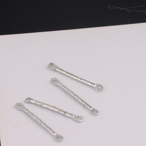 Close-up of four silver textured connector bars with double holes for DIY jewelry making