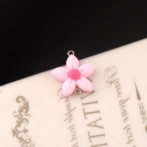 Detailopname van roze hars bloem hanger met zilveren dubbele lussen voor DIY sieraden