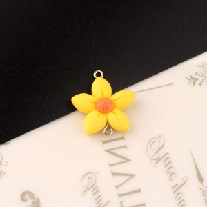 Detail van gele harsbloem met oranje kern en dubbele zilveren metalen ringen voor DIY