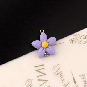 Detail van paarse bloembedels van hars met twee zilveren verbindingsringen voor sieraden