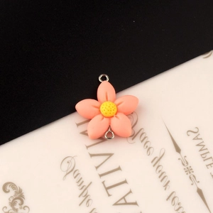 Detailopname van roze-oranje harsbloem hanger met dubbele zilveren ringen voor DIY sieraden