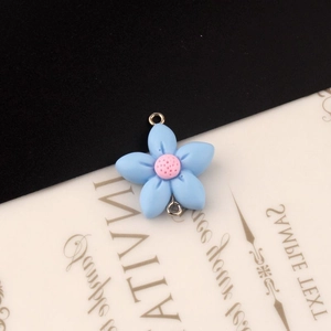 Detail van DIY lichtblauwe harsbloem met roze hart en dubbele ringen voor sieraden maken
