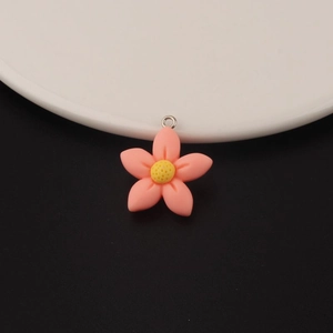 Detailopname van roze hars bloem hanger met geel hart en een zilveren metalen oogje