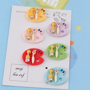 Flat lay of colorful resin artist palette charms with cute paintbrushes for DIY crafts