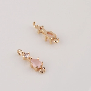 Vue détaillée de deux pendentifs goutte en zircon rose avec bordure en cuivre doré pour DIY