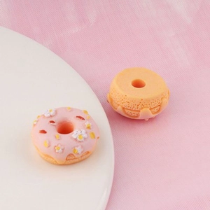 Macro detail of miniature resin donut models with flowers for DIY cream glue craft decoration