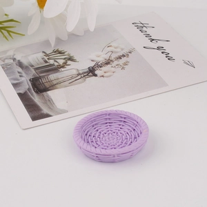 Detail view of mini purple round resin tray with faux woven texture on a white backdrop