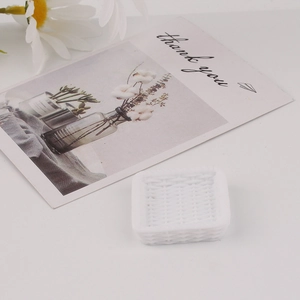 Detailed view of miniature white resin square tray with simulated woven basket texture