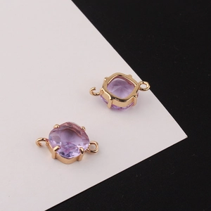 Vue macro des connecteurs de cristal losange violets plaqués or 18 carats pour bijoux DIY