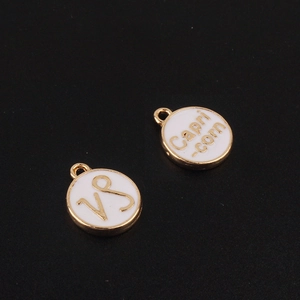 Gros plan sur breloques Capricorne en émail blanc et bordure dorée pour bijoux