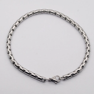 Gros plan d'un bracelet gourmette en acier inoxydable avec un fermoir mousqueton robuste