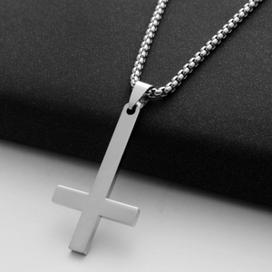 Detail of silver inverted cross pendant with brushed metal finish on box chain necklace