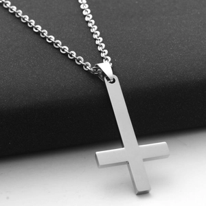 Close-up of polished stainless steel inverted cross pendant on a classic chain