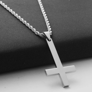Close-up of a silver stainless steel inverted cross pendant with a twisted rope chain