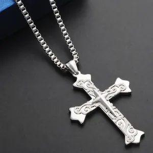 Detail shot of multi-layer stainless steel cross pendant with intricate floral engravings