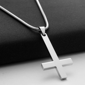 Macro view of polished silver inverted cross pendant with sleek stainless steel snake chain