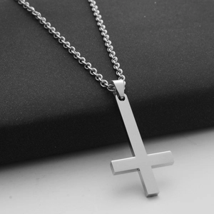 Close-up of polished silver stainless steel inverted cross pendant on a rolo chain