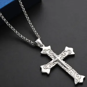 Detail shot of a double-layered cross pendant with floral relief and polished finish