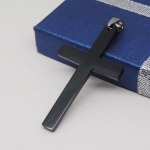 Gepolijste zwarte roestvrijstalen kruis hanger op een blauwe sieraden geschenkdoos