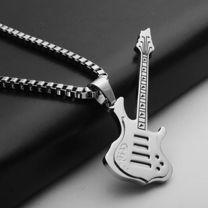 Detailed macro view of a silver guitar pendant with intricate laser-engraved details