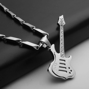 Detailed close-up of a silver-tone guitar pendant with bamboo-style chain on black leather