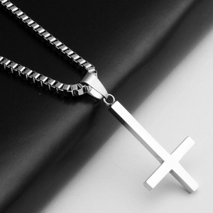 Macro shot of silver stainless steel inverted cross pendant on a classic box chain necklace
