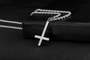 Close-up of polished silver inverted cross pendant on a durable steel rope chain