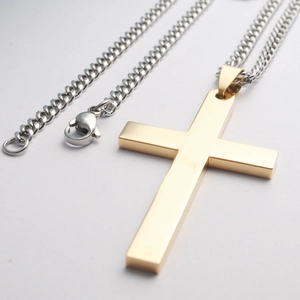 Detailopname van de gepolijste gouden kruis hanger met zilveren roestvrijstalen schakelketting