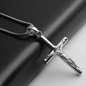 Détail macro du pendentif crucifix en acier inoxydable poli avec relief de Jésus