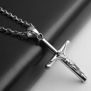 Vue macro d'un pendentif crucifix en acier inoxydable argenté au fini poli