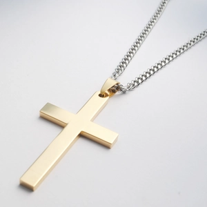 Detail van gepolijste gouden kruishanger met zilveren cubaanse schakelketting heren