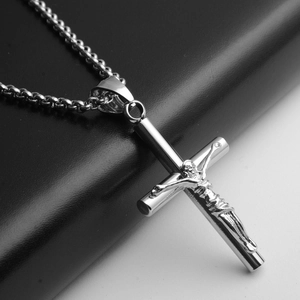 Détail macro du collier pendentif crucifix en acier inoxydable argenté avec texture polie