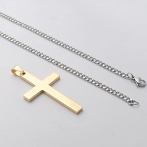 Macro-detail van gouden kruisbedel met zilveren schakelketting en karabijnsluiting