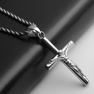 Vue détaillée du pendentif croix en acier avec figure de Jésus et sa chaîne de type corde
