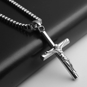 Gros plan détaillé du pendentif crucifix en acier inoxydable et chaîne vénitienne