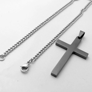 Detail van matzwarte kruishanger met zilveren roestvrijstalen schakelketting en karabijnsluiting