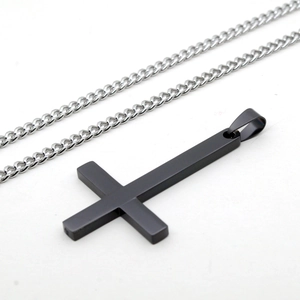 Détail d'un pendentif croix noir mat avec chaîne en argent polie pour hommes