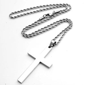 Macro detail van zilveren roestvrijstalen kruishanger met gedraaide touwketting