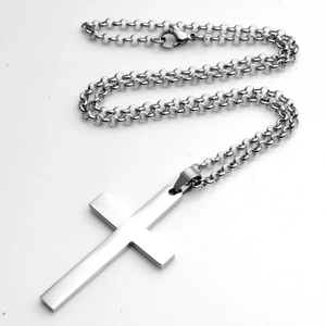 Detailopname van minimalistische zilveren roestvrijstalen kruishanger met rolo ketting