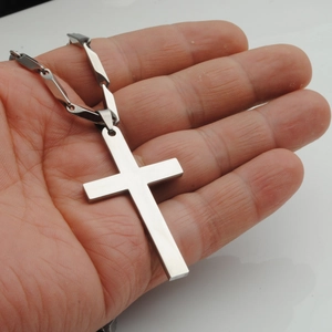 Detailopname van een zilveren roestvrijstalen kruishanger met stevige metalen ketting