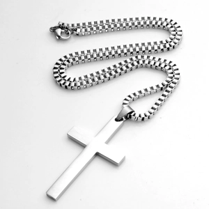 Detail van gepolijste zilveren kruis hanger met een stijlvolle stalen box ketting