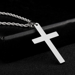 Macro-opname van een minimalistische roestvrijstalen kruishanger aan touwketting