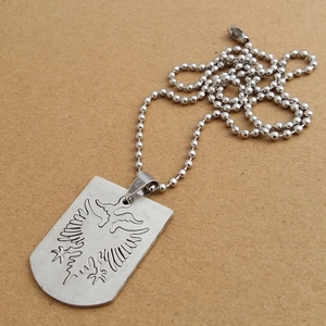 Detailed close-up of a silver Albanian double-headed eagle pendant on a bead chain necklace