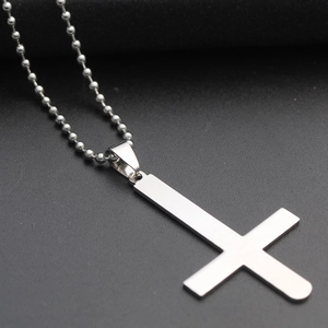 Makroaufnahme eines polierten Inverted-Cross-Anhängers aus Edelstahl an einer Kugelkette