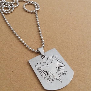 Detail of silver stainless steel shield pendant with engraved double-headed eagle pattern