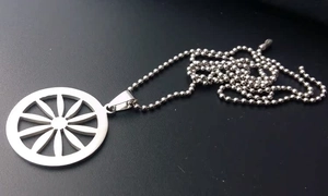 Detalle del colgante circular plateado con diseño de pétalos en una cadena de bolas