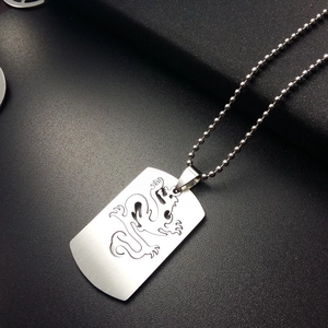 Detalle del colgante de dragón en acero inoxidable cepillado sobre fondo de cuero negro