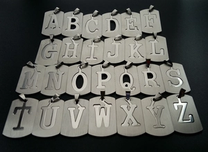 Macro view of 26 stainless steel alphabet letter pendants with brushed metal texture