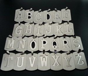 Detailed view of 26 stainless steel alphabet dog tag pendants with hollow-out design